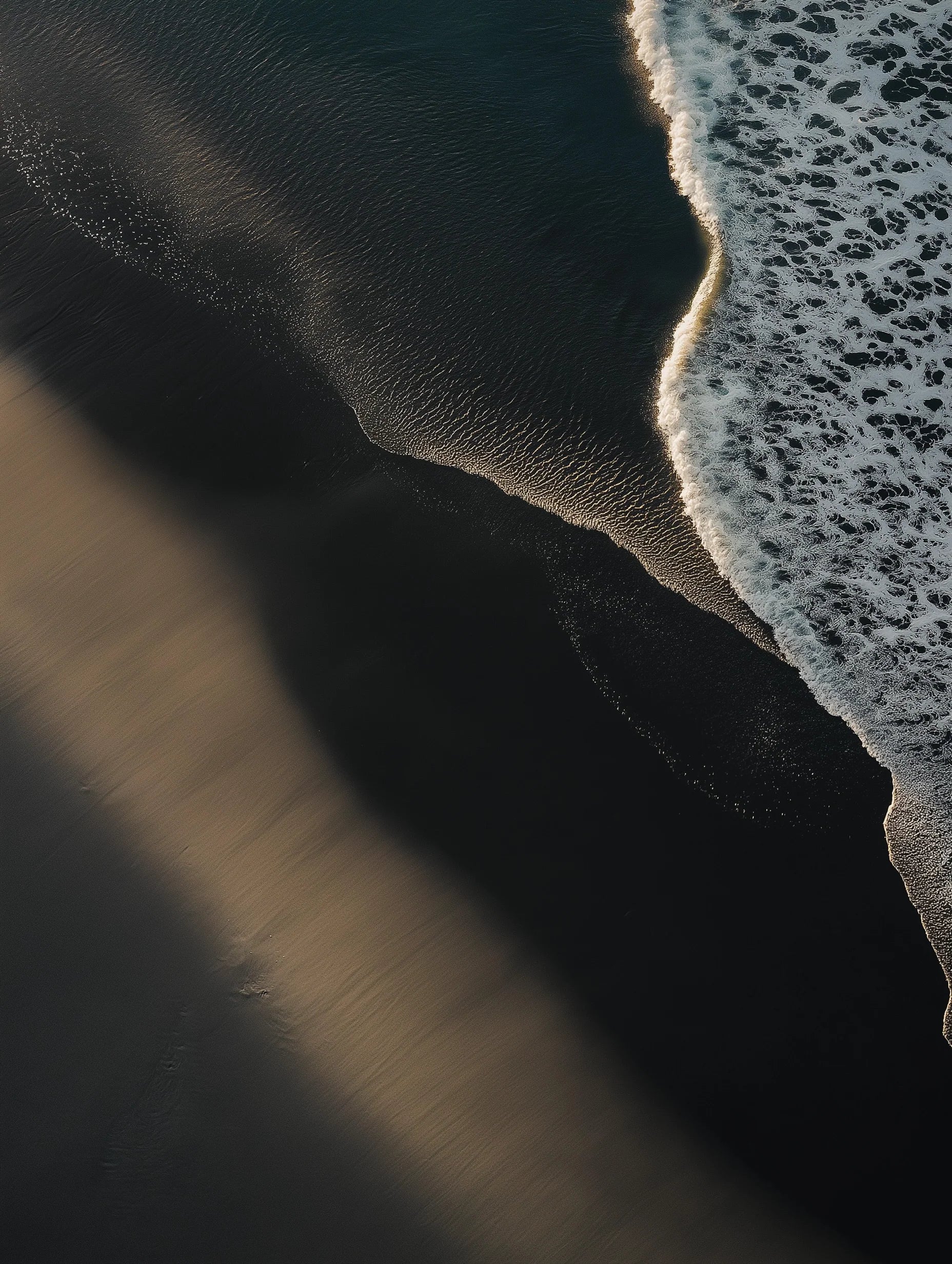 Close-up of a wave crashing onto a sandy beach